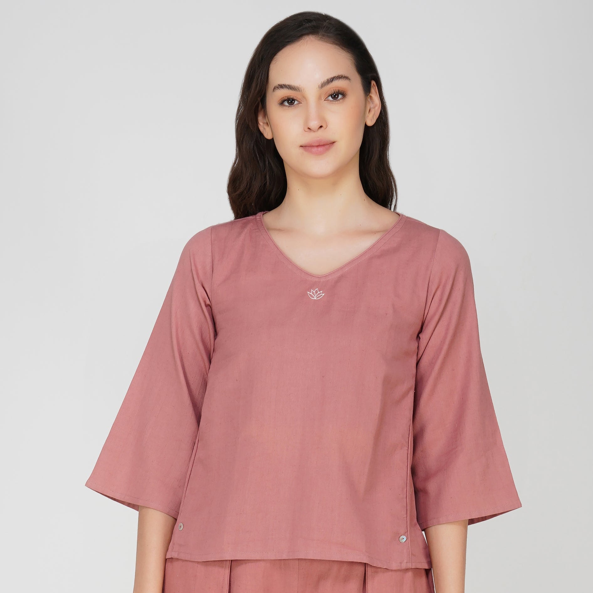 Woman wearing a pink top on a white background