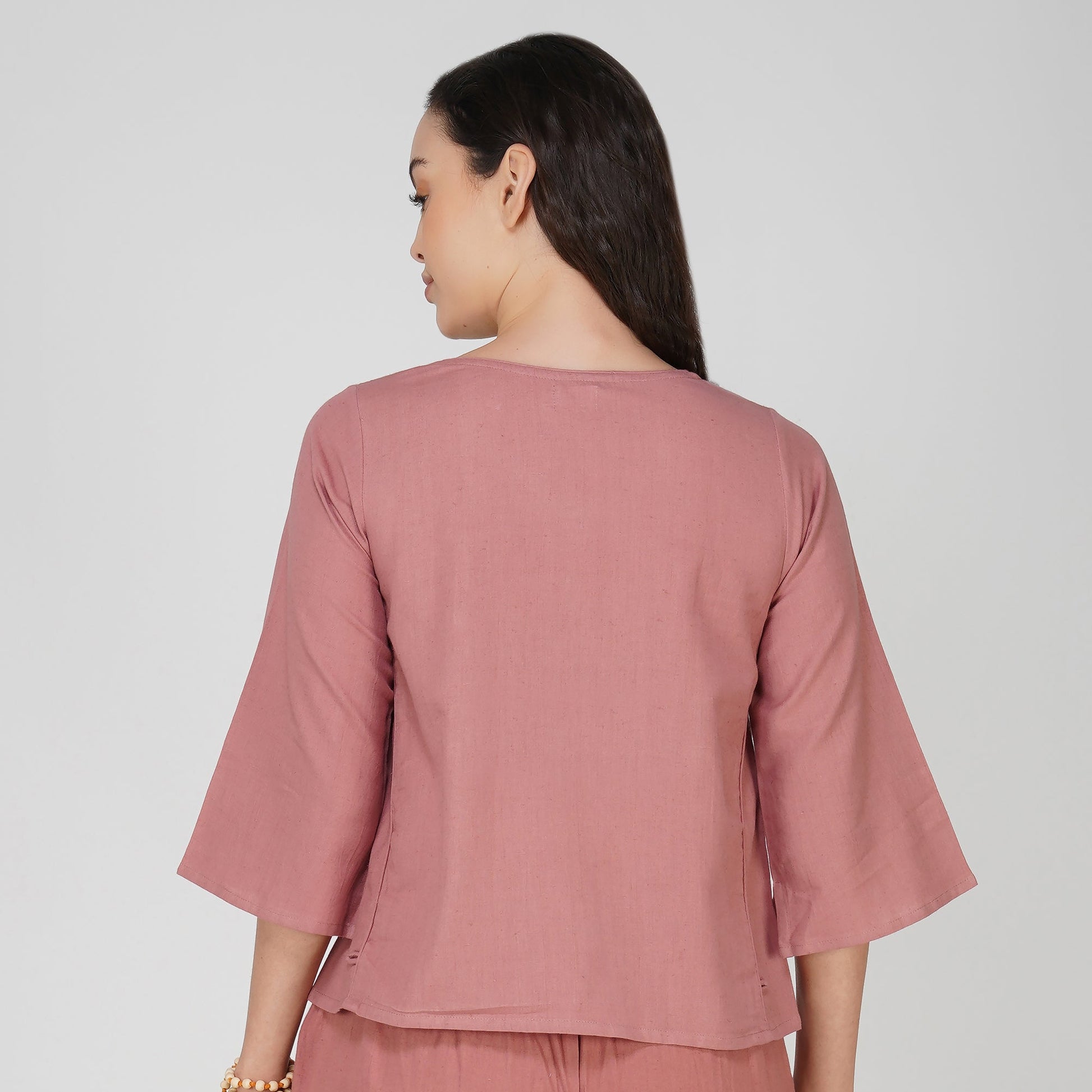 Woman wearing a pink top on a white background